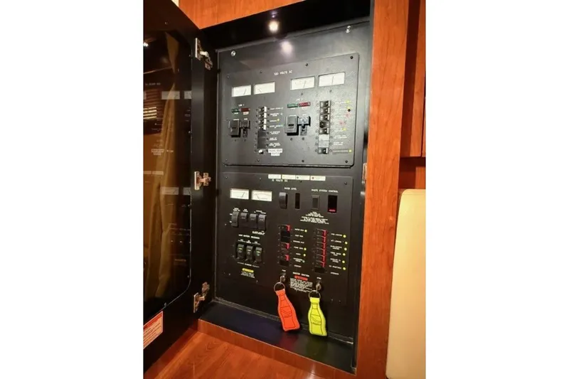Slide: The Image of Electrical panel inside 2006 Sea Ray 38 Sundancer yacht, featuring switches and circuit breakers. - 47