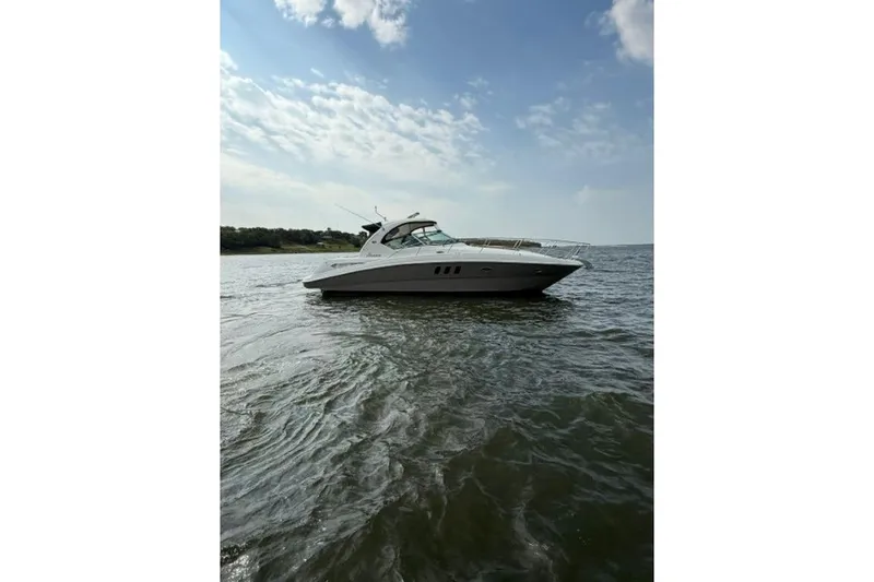 Slide: The Image of 2006 Sea Ray 38 Sundancer yacht cruising on open water under a partly cloudy sky. - 50
