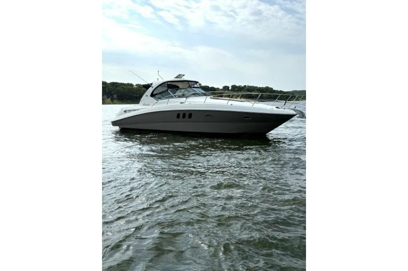 Slide: The Image of 2006 Sea Ray 38 Sundancer yacht on calm water under a cloudy sky. - 53