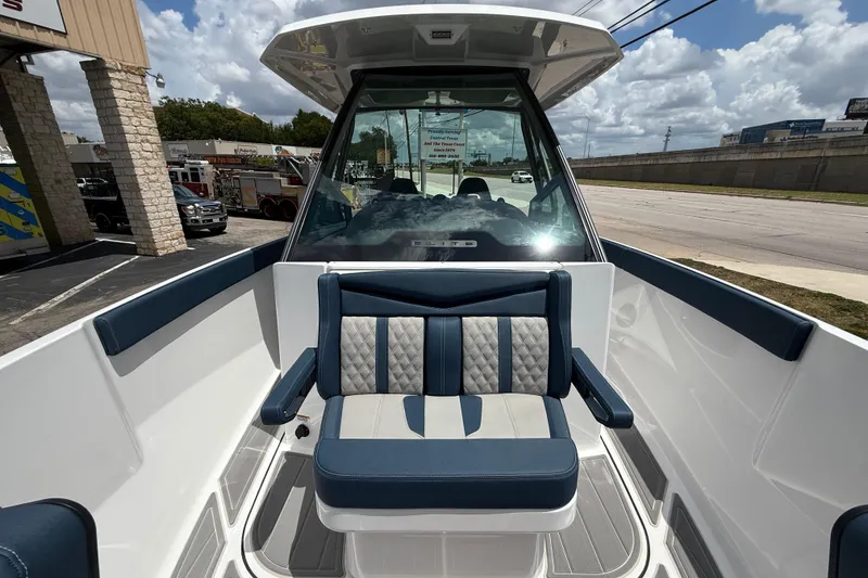 Slide: The Image of 2026 Monterey 27 SD Elite boat interior with blue and white seating, docked outdoors. - 11