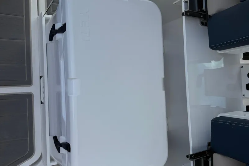 Slide: The Image of White cooler on 2026 Monterey 27 SD Elite boat deck, with blue seating nearby. - 13