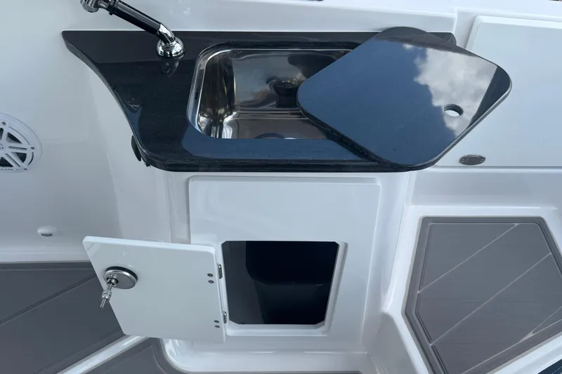 Slide: The Image of 2026 Monterey 27 SD Elite boat sink with black countertop and storage compartment. - 7