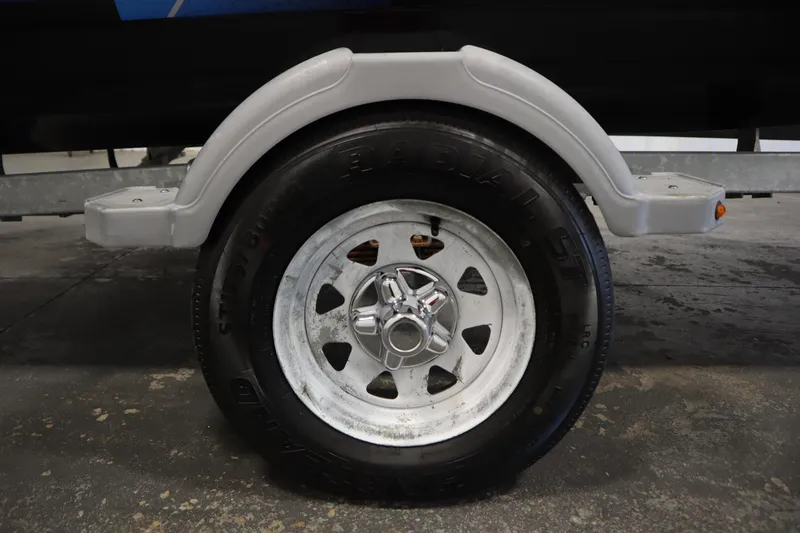 Slide: The Image of Trailer wheel of a 2021 Bayliner 16 Element boat, featuring a metal rim and black tire. - 37