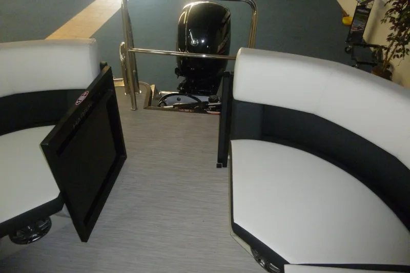 Slide: The Image of Interior of 2025 Harris Breese 210 boat with white seating and motor view. - 5