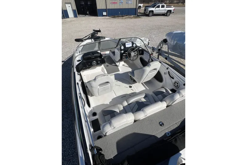 Slide: The Image of 2020 Nitro Z19 Sport boat interior with seating and steering wheel, parked outdoors. - 14