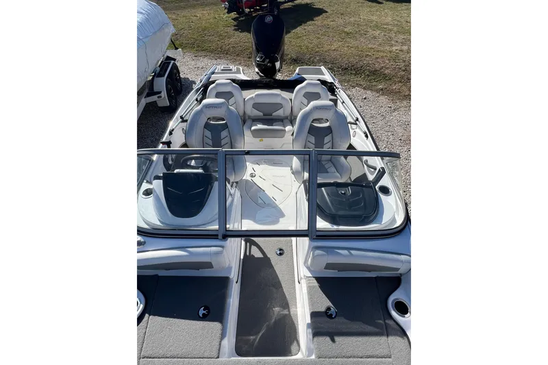 Slide: The Image of 2020 Nitro Z19 Sport boat interior with seating and windshield, parked on gravel. - 8