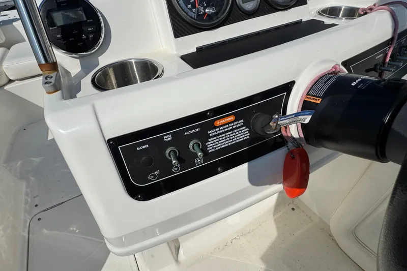 Slide: The Image of 2015 Bayliner 190 Deck Boat dashboard with controls and warning label. - 11