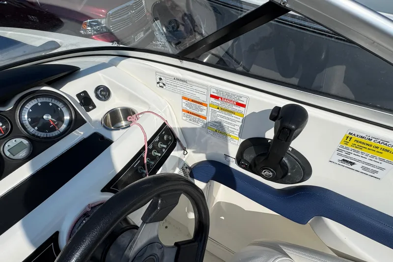 Slide: The Image of 2015 Bayliner 190 Deck Boat dashboard with gauges, controls, and capacity warning labels. - 12