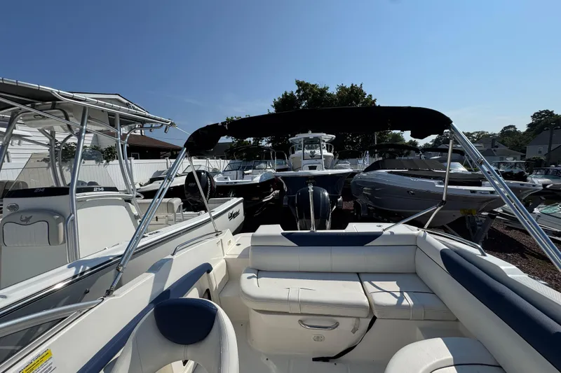Slide: The Image of 2015 Bayliner 190 Deck Boat with seating, surrounded by other boats in a marina. - 20