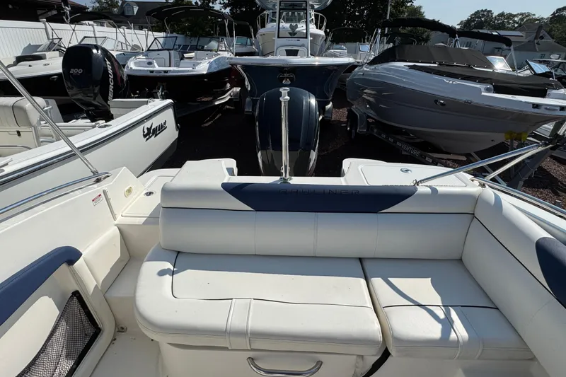 Slide: The Image of 2015 Bayliner 190 Deck Boat with white seating, surrounded by other boats. - 3