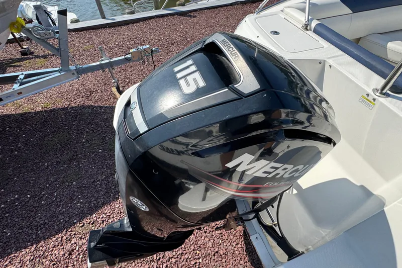 Slide: The Image of 2015 Bayliner 190 Deck Boat with Mercury 115 outboard motor, docked by the water. - 4