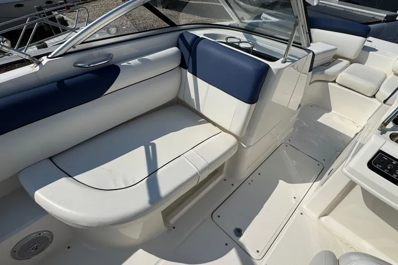 Slide: The Image of 2015 Bayliner 190 Deck Boat interior with white and blue seating, sleek design. - 7