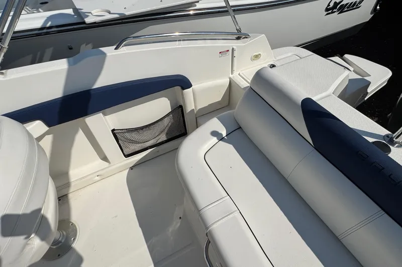 Slide: The Image of 2015 Bayliner 190 Deck Boat interior with white seating and storage compartment. - 8