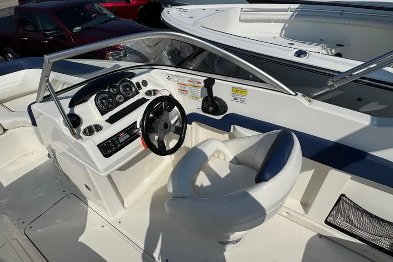 Slide: The Image of 2015 Bayliner 190 Deck Boat cockpit with steering wheel and dashboard controls. - 9
