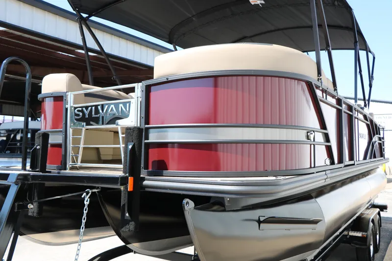 Slide: The Image of 2025 Sylvan L3 DLZ pontoon boat with red exterior and beige seating. - 11