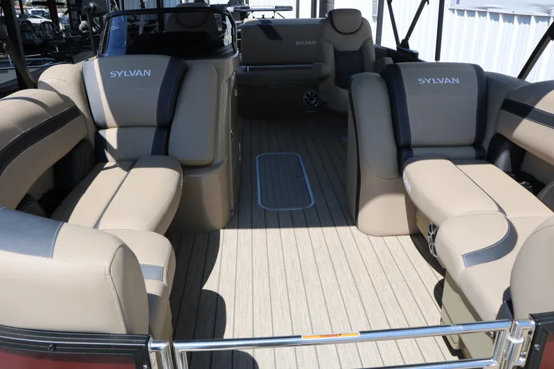 Slide: The Image of 2025 Sylvan L3 DLZ pontoon boat interior with beige seating and wood-style flooring. - 15