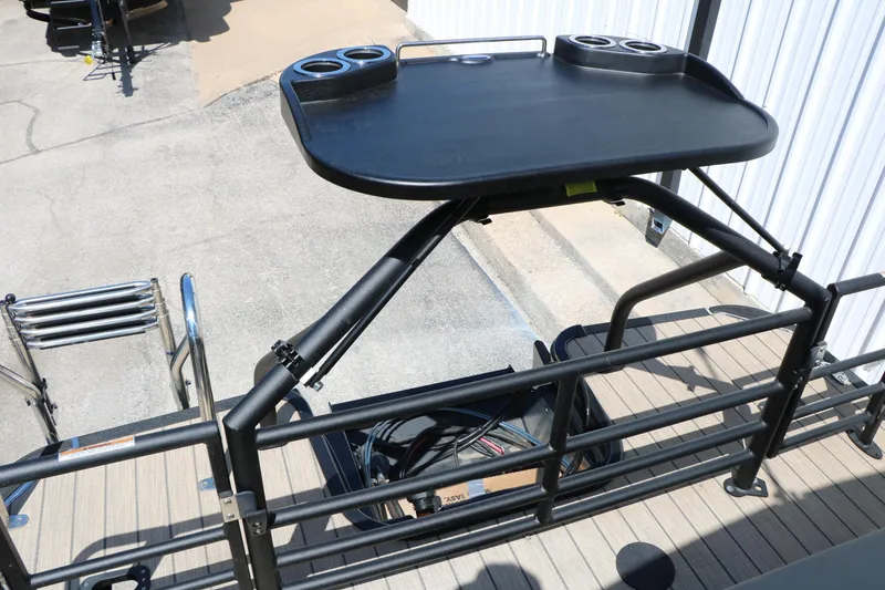 Slide: The Image of 2025 Sylvan L3 DLZ pontoon boat with elevated black table and cup holders. - 21