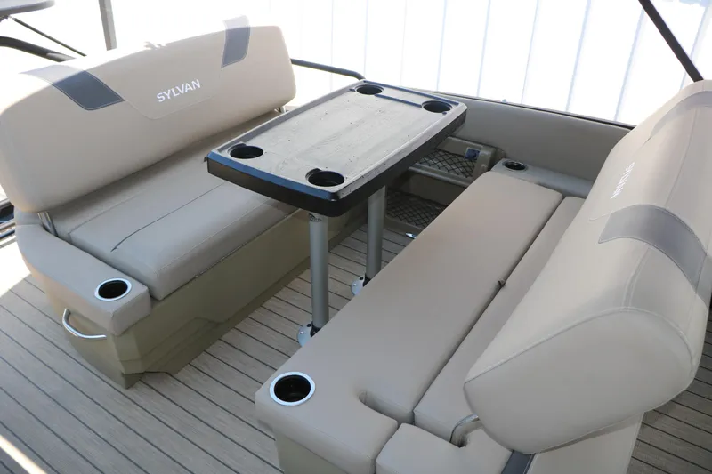 Slide: The Image of 2025 Sylvan L3 DLZ boat interior with beige seating and a central table. - 25