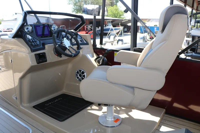 Slide: The Image of Captain's chair and helm of 2025 Sylvan L3 DLZ boat, featuring modern controls and steering wheel. - 28