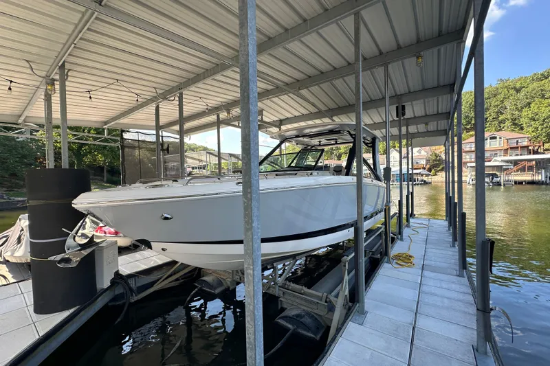 Slide: The Image of 2020 Chaparral 300 OSX boat docked under covered marina. - 1