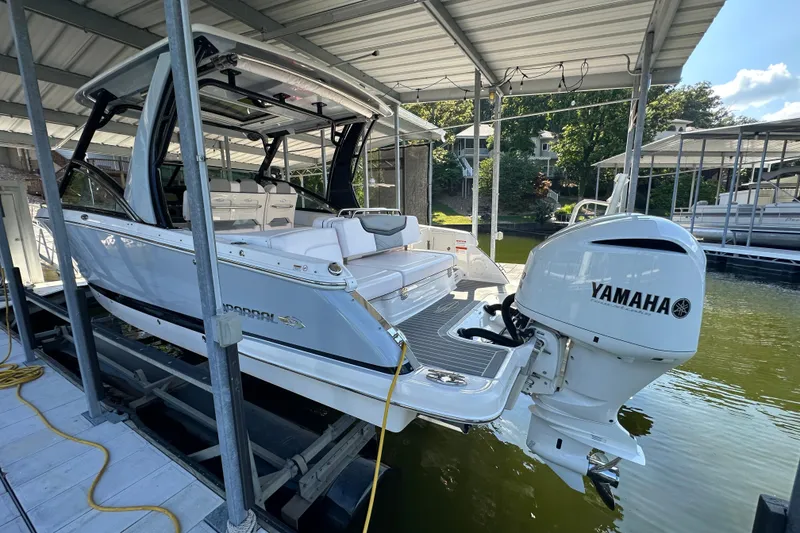 Slide: The Image of 2020 Chaparral 300 OSX boat with Yamaha engine docked under a covered marina. - 10