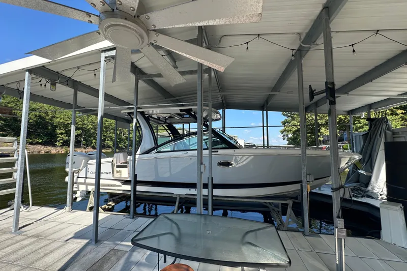 Slide: The Image of 2020 Chaparral 300 OSX boat docked under covered marina with ceiling fan. - 3