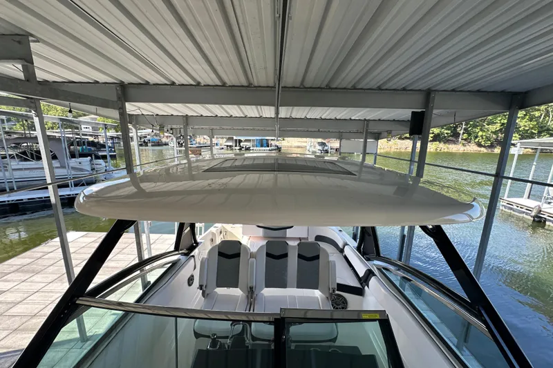 Slide: The Image of 2020 Chaparral 300 OSX boat docked under covered marina. - 33