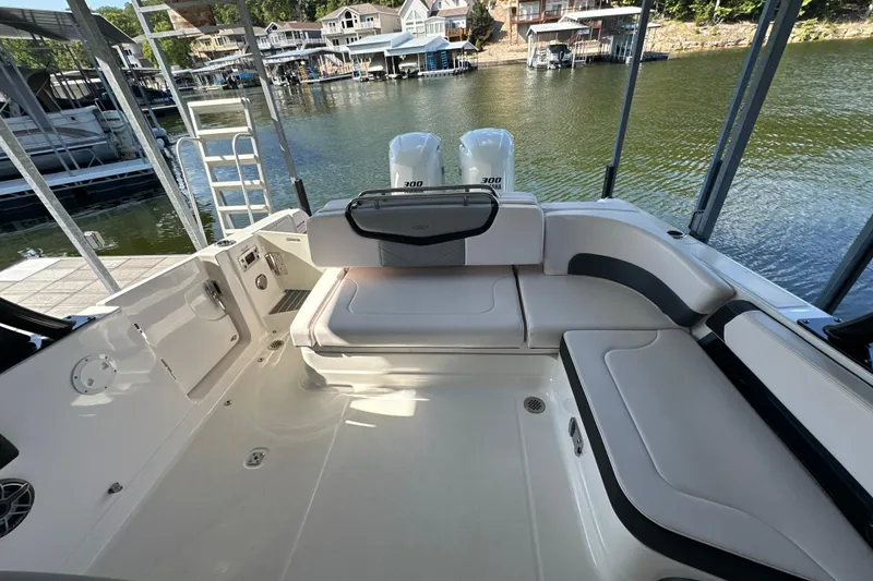 Slide: The Image of 2020 Chaparral 300 OSX boat interior with seating, docked by a scenic waterfront. - 37