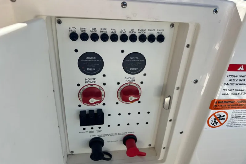 Slide: The Image of Control panel of a 2020 Chaparral 300 OSX boat with power switches and warning labels. - 39