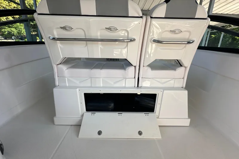 Slide: The Image of 2020 Chaparral 300 OSX boat interior with white seating and storage compartment. - 40