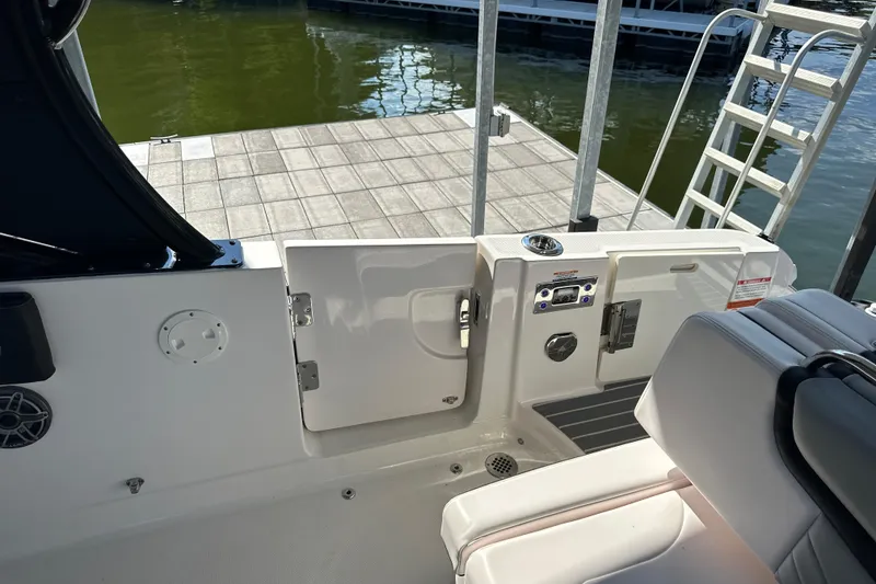 Slide: The Image of 2020 Chaparral 300 OSX boat interior with open door and dock view. - 50
