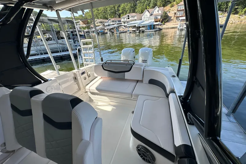 Slide: The Image of 2020 Chaparral 300 OSX boat interior with seating, docked by waterfront homes. - 52