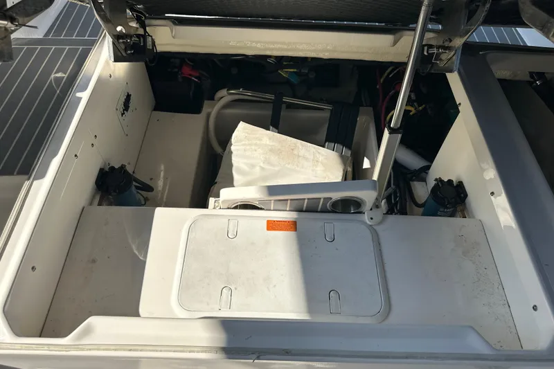 Slide: The Image of 2020 Chaparral 300 OSX boat storage compartment with open hatch and visible equipment. - 54