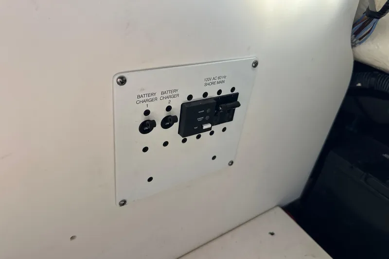 Slide: The Image of Control panel on 2020 Chaparral 300 OSX boat with battery chargers and shore power switch. - 56