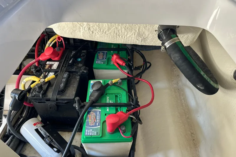 Slide: The Image of 2020 Chaparral 300 OSX boat battery compartment with connected cables. - 57