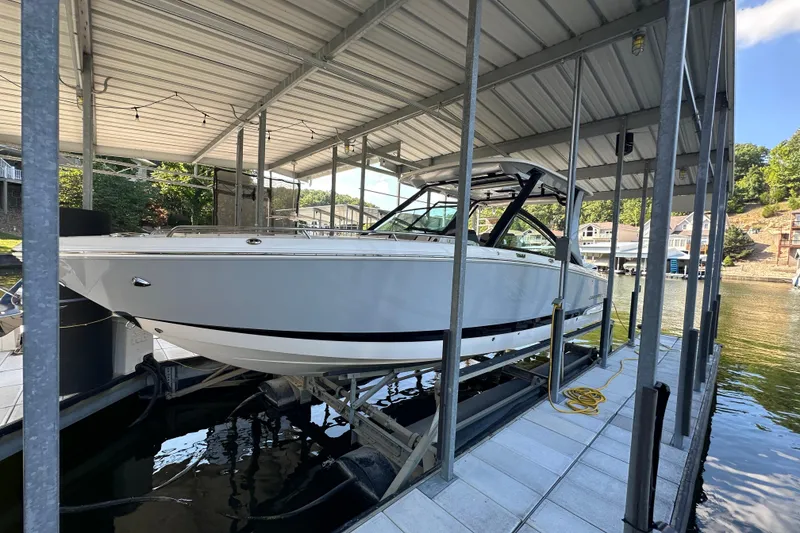 Slide: The Image of 2020 Chaparral 300 OSX boat docked in a covered marina slip. - 6