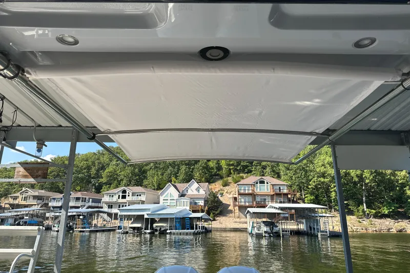 Slide: The Image of 2020 Chaparral 300 OSX boat with canopy, docked near waterfront homes. - 60