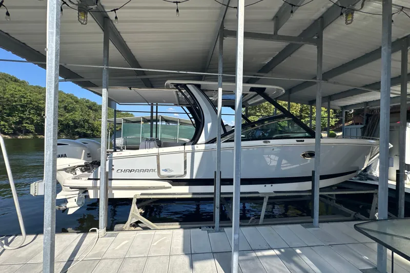 Slide: The Image of 2020 Chaparral 300 OSX boat docked under a covered marina. - 61