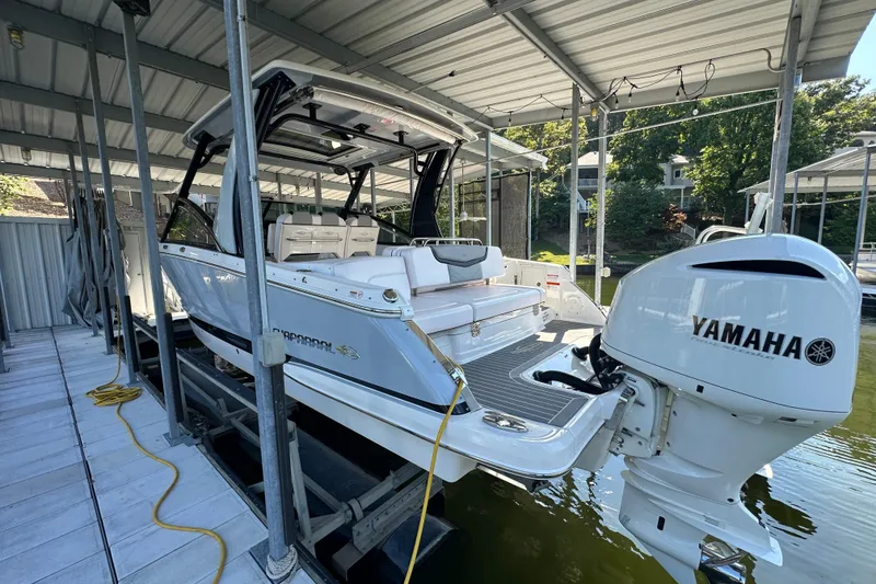 Slide: The Image of 2020 Chaparral 300 OSX boat with Yamaha engine docked under a covered marina. - 8