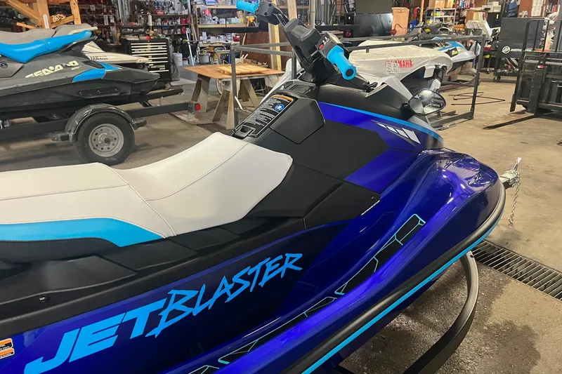 Slide: The Image of 2024 Yamaha JETBLASTER jet ski in a workshop, featuring a sleek blue and white design. - 0