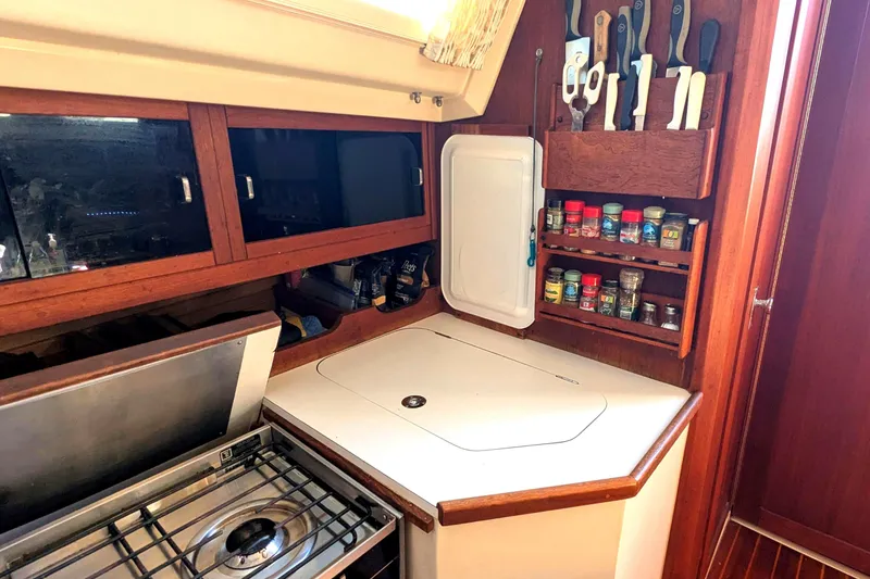 Slide: The Image of 1990 Catalina 42 yacht kitchen with stove, spice rack, and knife holder. - 17