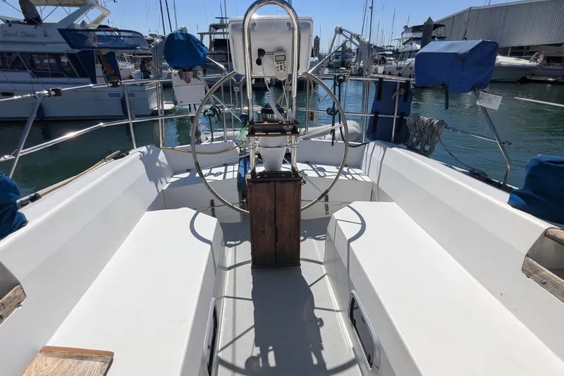 Slide: The Image of 1990 Catalina 42 sailboat cockpit with steering wheel, docked in marina. - 2