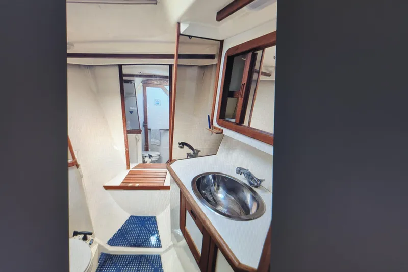 Slide: The Image of Cozy cabin interior of 1990 Catalina 42 sailboat with blue cushions and wooden accents. - 25