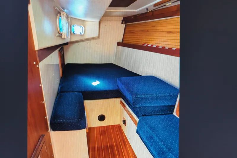 Slide: The Image of Interior cabin of a 1990 Catalina 42 sailboat with blue cushions and wood paneling. - 26