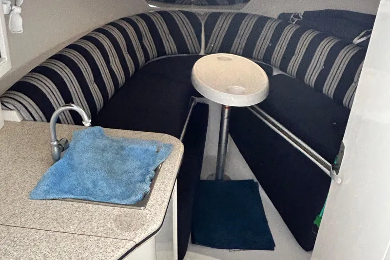 Slide: The Image of Interior of 2003 Intrepid 310 Walkaround with striped seating and compact kitchenette. - 10