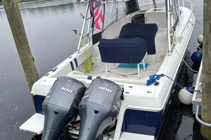 Slide: The Image of 2003 Intrepid 310 Walkaround boat docked with twin 300 horsepower engines. - 11