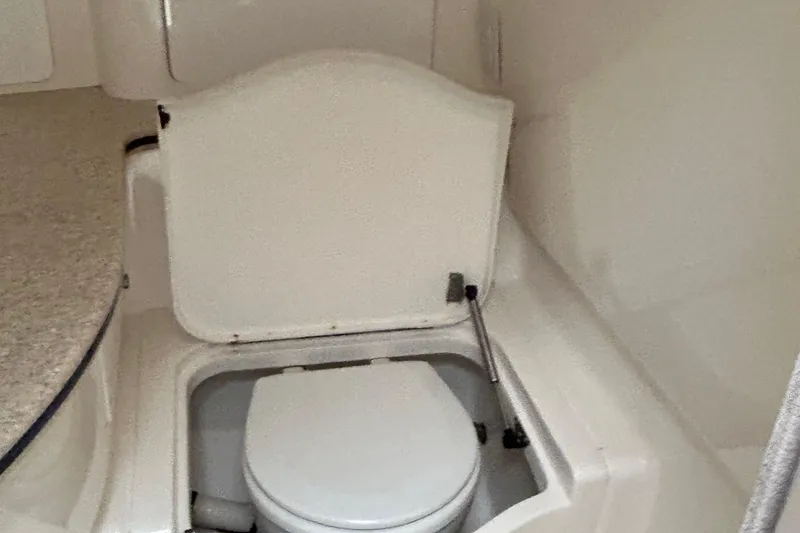 Slide: The Image of 2003 Intrepid 310 Walkaround boat interior with compact marine toilet. - 12