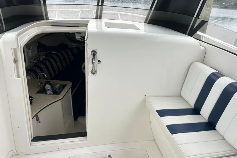 Slide: The Image of 2003 Intrepid 310 Walkaround interior with striped seating and cabin entrance. - 5