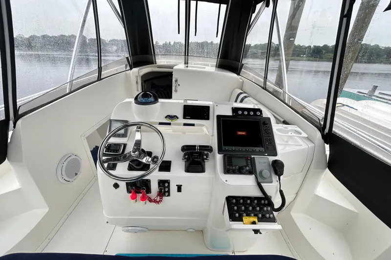 Slide: The Image of 2003 Intrepid 310 Walkaround boat cockpit with steering wheel and navigation equipment. - 6
