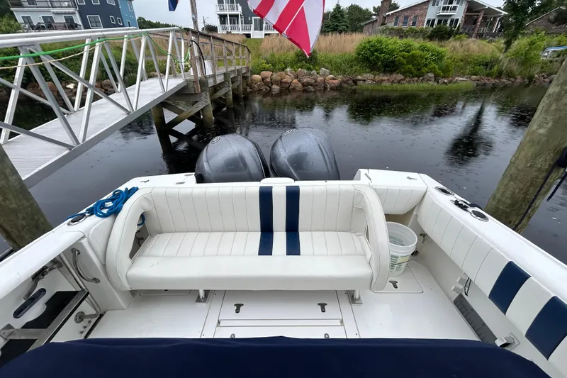 Slide: The Image of 2003 Intrepid 310 Walkaround boat docked, featuring dual engines and white seating with blue accents. - 7
